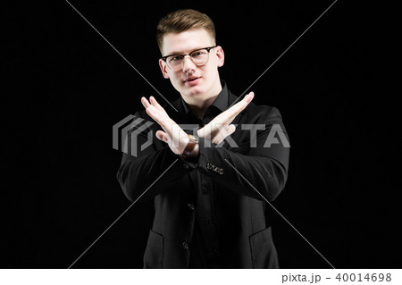 Portrait of confident handsome elegant responsible businessman showing stop gesture on black 40014698