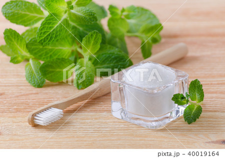 alternative natural toothpaste xylitol, soda, salt, and wood toothbrush, mint on wooden 40019164