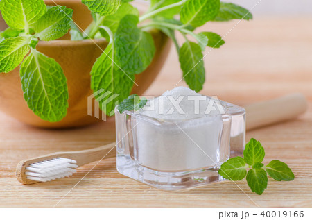 alternative natural toothpaste xylitol, soda, salt, and wood toothbrush closeup, mint on wooden 40019166