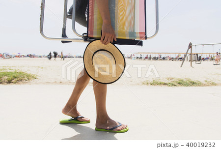young man carrying a beach chair 40019232