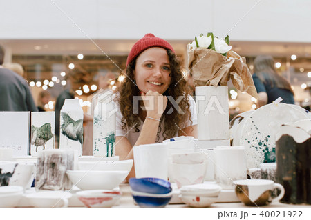 Girl selling handmade ceramics market counter Girl selling handmade ceramics market counter 40021922