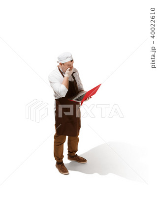 Serious butcher posing with a laptop isolated on white background Serious butcher posing with a laptop isolated on white background 40022610