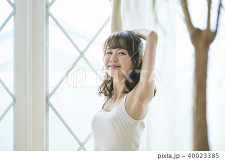 窓際で伸びをする女性 40023385