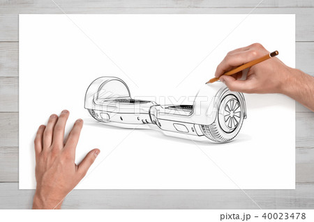 Male hands drawing a gyroscooter with a pencil on a large piece of paper. Male hands drawing a gyroscooter with a pencil on a large piece of paper. 40023478