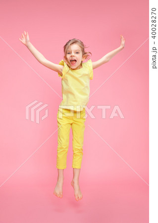 Excited girl jumping in studio Excited girl jumping in studio 40028270