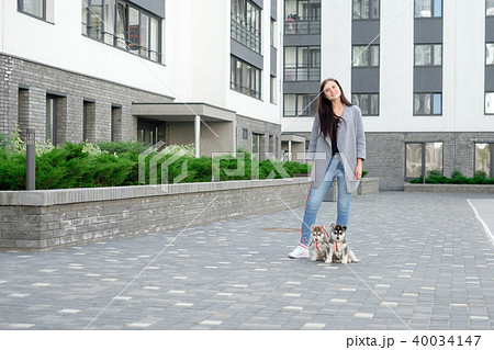 Young attractive women walking with two husky puppy on the street 40034147