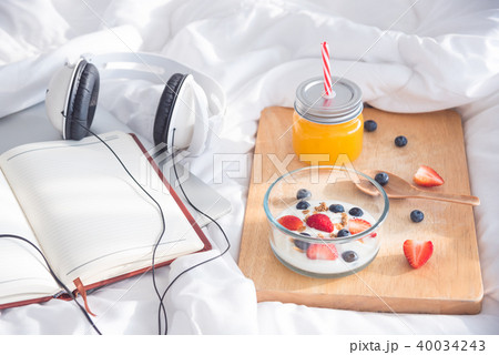 Yogurt with many berries in bowl with orange juice Yogurt with many berries in bowl with orange juice 40034243