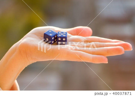 Dice 2 5 in the female hand, sunset background. 40037871