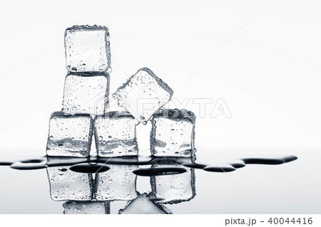 Ice cubes on glossy table on white background 40044416