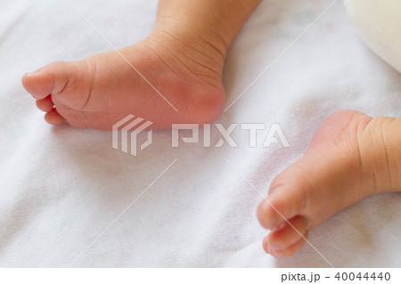 Newborn baby infant feet on white bed 40044440