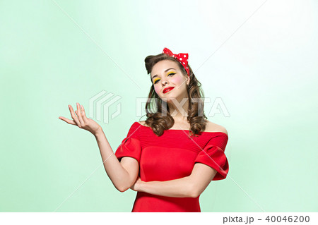 Beautiful young woman with pinup make-up and hairstyle. Studio shot on white background Beautiful young woman with pinup make-up and hairstyle. Studio shot on white background 40046200