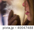 A young girl smokes a cigarette in the winter  40047488
