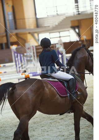 Young rider on the stallion jumping throw the hurdle 40048770