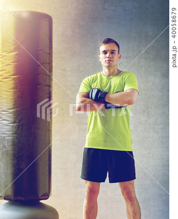 man with boxing gloves and punching bag in gym man with boxing gloves and punching bag in gym 40058679