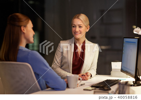 happy businesswomen talking late at night office 40058816