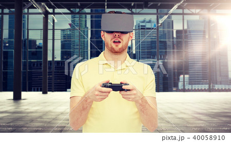 man in virtual reality headset with gamepad 40058910