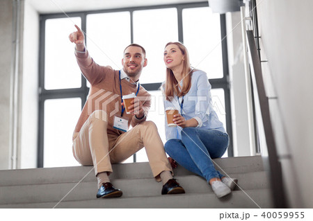 man and woman with conference badges drink coffee 40059955