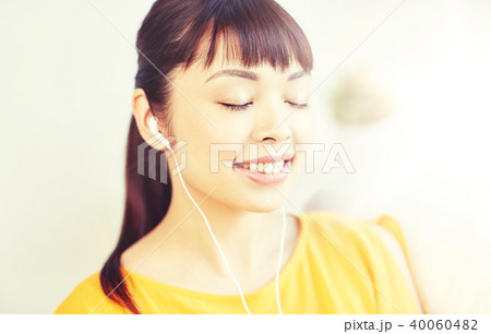 happy asian woman with earphones listening music 40060482