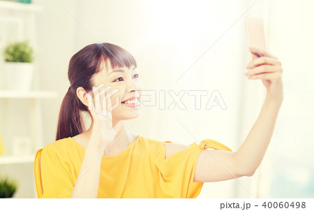 happy asian woman taking selfie with smartphone happy asian woman taking selfie with smartphone 40060498