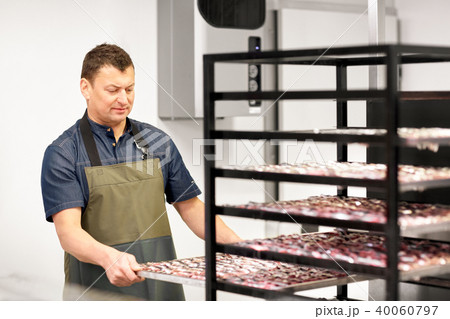 man with smoking tray at fish shop or smokehouse man with smoking tray at fish shop or smokehouse 40060797