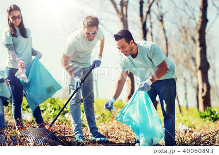 volunteers with garbage bags cleaning park area 40060893