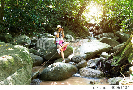 Asian hipster women take a photo of waterfall Asian hipster women take a photo of waterfall 40063184