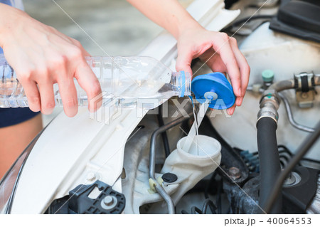 Hands of filling water into the canister of car. Hands of filling water into the canister of car. 40064553