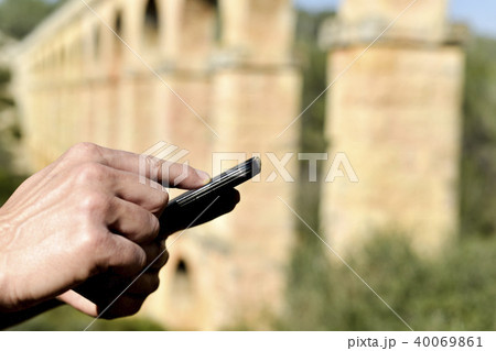 man with phone at the roman aqueduct of Tarragona 40069861