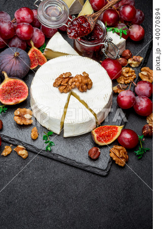Camembert cheese and walnuts on stone serving board 40070894