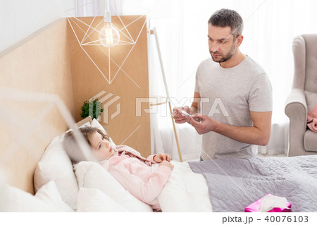 Worried daddy taking care of his sick daughter Worried daddy taking care of his sick daughter 40076103
