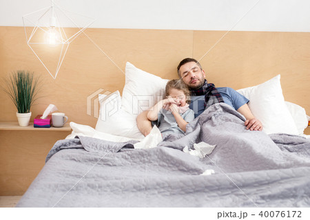 Unwell father and daughter sleeping together  40076172