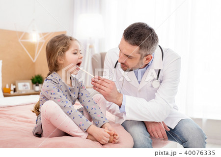 Experienced doctor examining girls throat Experienced doctor examining girls throat 40076335