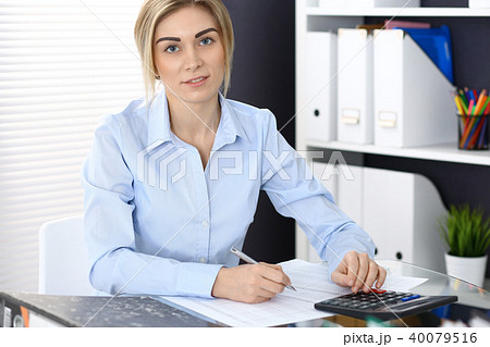 Portrait of female bookkeeper or financial inspector  making report, calculating or checking balanc 40079516