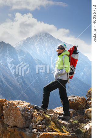 A girl backpacker stands on top of a mountain A girl backpacker stands on top of a mountain 40086753