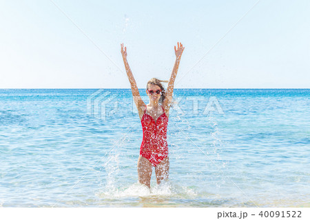 Cheerful pretty woman splashing at the sea Cheerful pretty woman splashing at the sea 40091522