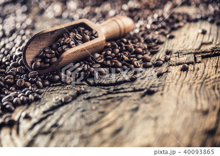 Wooden scoop full of coffee beans on old oak table 40093865