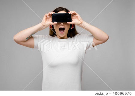 Young woman with telephone and earphones 40096970