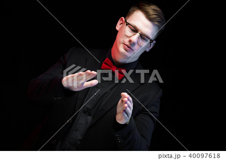 Portrait of confident handsome elegant responsible businessman with hands near his chest on black 40097618