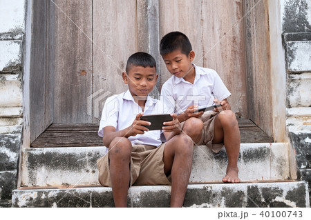 Two asian boys wearing school uniforms are playing 40100743