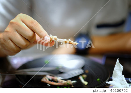 Hand holding bone of Roasted chicken leg Hand holding bone of Roasted chicken leg 40100762