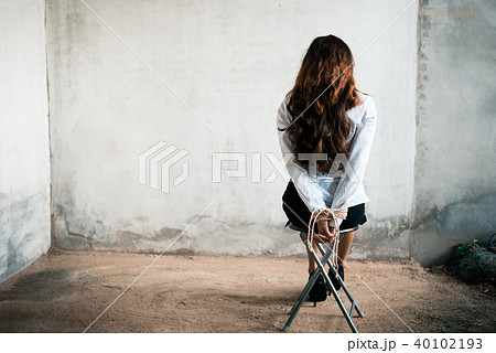 Back view of hostage woman with tie rope in hands 40102193