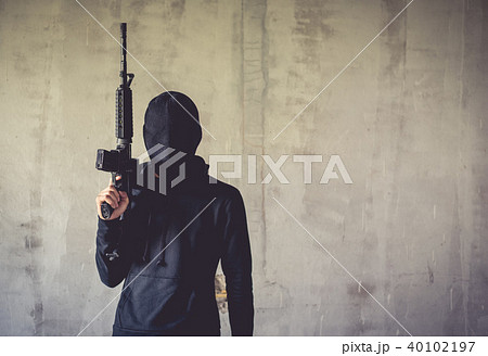 Terrorist holding rifle gun on grunge wall Terrorist holding rifle gun on grunge wall 40102197