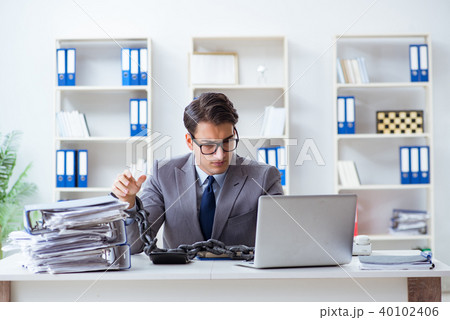 Busy employee chained to his office desk 40102406