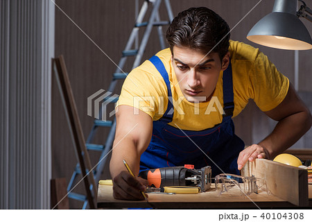 Worker working in repair workshop in woodworking concept 40104308
