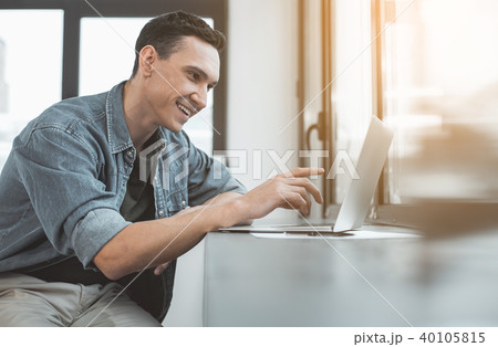 Beaming man looking at laptop Beaming man looking at laptop 40105815