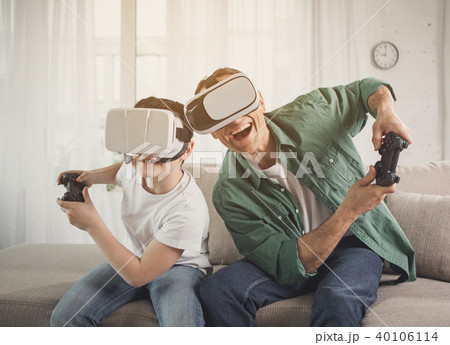 Joyful father and son enjoying competition via modern technologies Joyful father and son enjoying competition via modern technologies 40106114