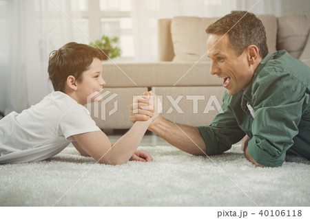 Joyful man and boy are measuring their strength in arms 40106118