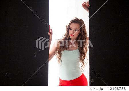 Portrait of fashionable girl in red pants on a black background 40108788