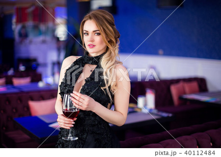 beautiful sensual woman in elegant clothes sitting in cafe, drinking vine 40112484