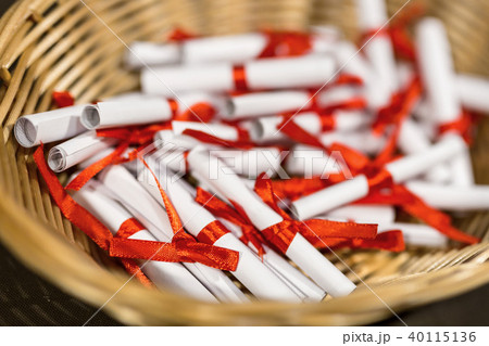 Pile of small paper scrolls in wicked basket 40115136